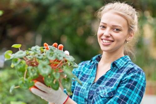 Gardener assessing a small front garden next to a pond