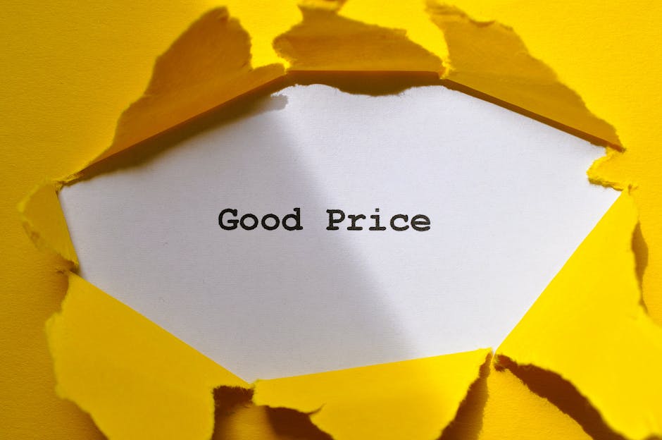 The image shows a white piece of paper with the words 'Good Price' printed in black ink, torn through a bright yellow background that appears to be torn paper or cardboard. The torn edges of the yello